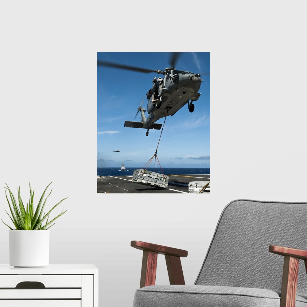 A modern room featuring Pacific Ocean, August 7, 2011 - An MH-60S Sea Hawk helicopter lowers cargo onto the deck of the N...