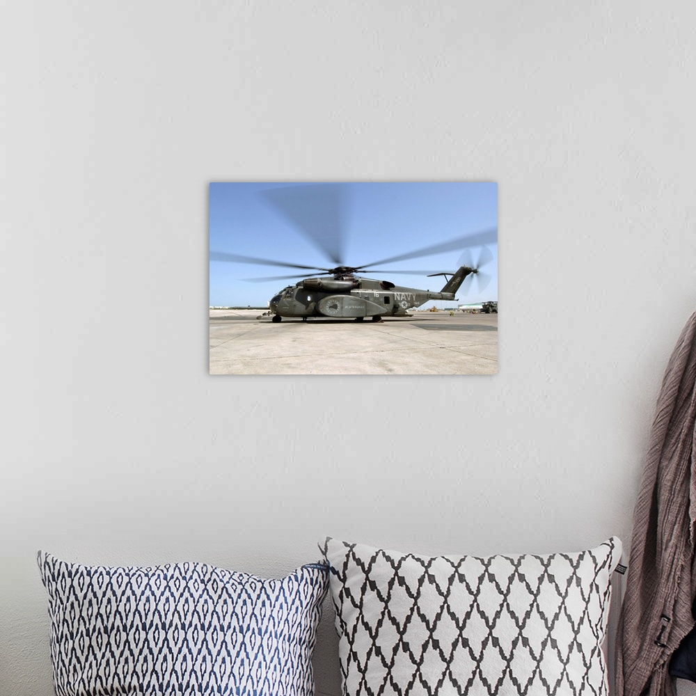 A bohemian room featuring An MH53E Sea Dragon helicopter sits ready on the flight line