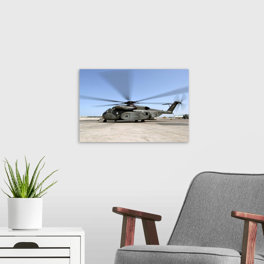 A modern room featuring An MH53E Sea Dragon helicopter sits ready on the flight line