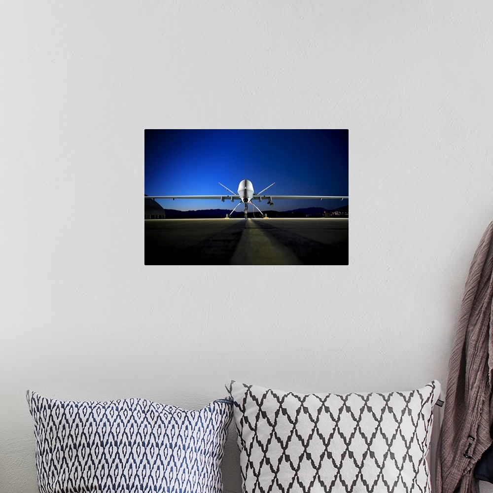 A bohemian room featuring Photograph of airplane on runway with mountain silhouette in the distance at night.