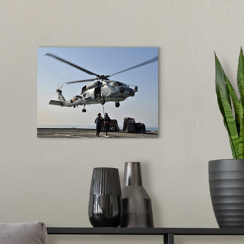 A modern room featuring An SH-60F Sea Hawk helicopter picks up supplies from USS Gunston Hall.