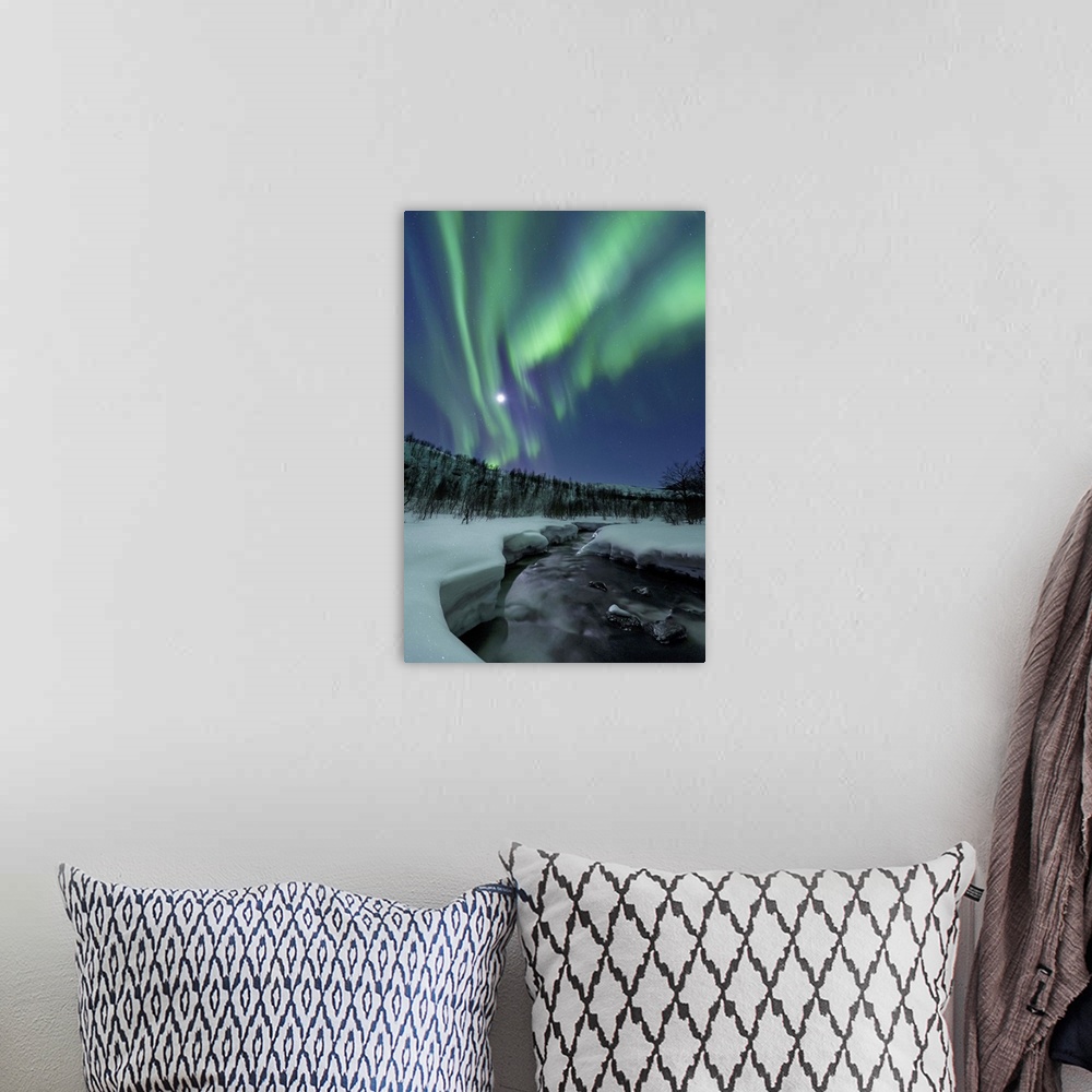 A bohemian room featuring Aurora Borealis over Blafjellelva River in Troms County, Norway. Auroras are the result of the em...