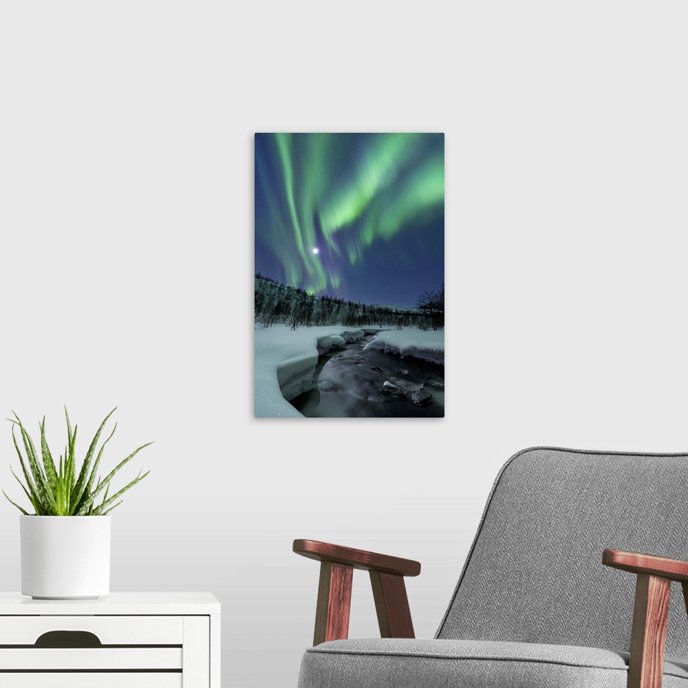 A modern room featuring Aurora Borealis over Blafjellelva River in Troms County, Norway. Auroras are the result of the em...