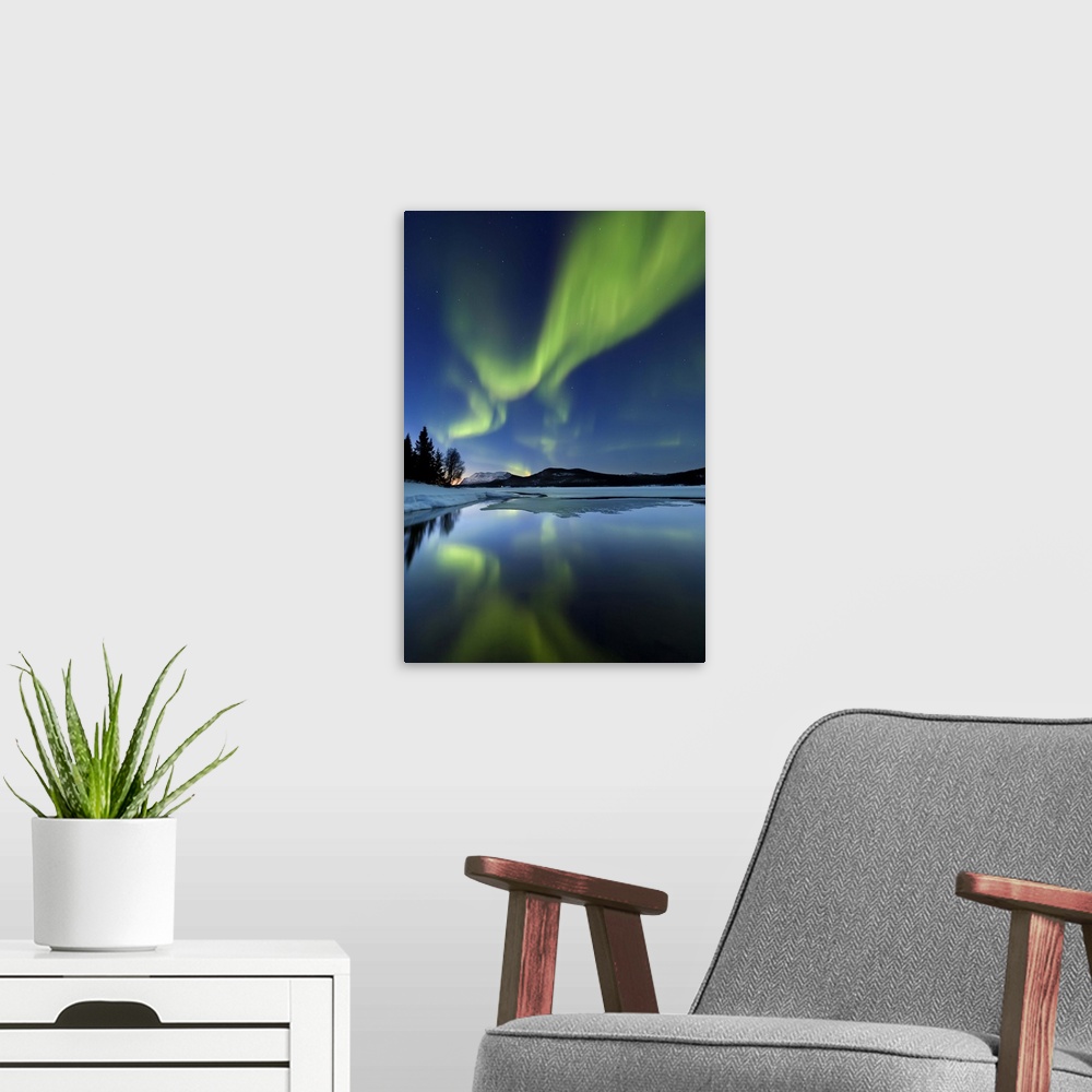 A modern room featuring Aurora borealis over Sandvannet Lake in Troms County, Norway. Auroras are the result of the emiss...