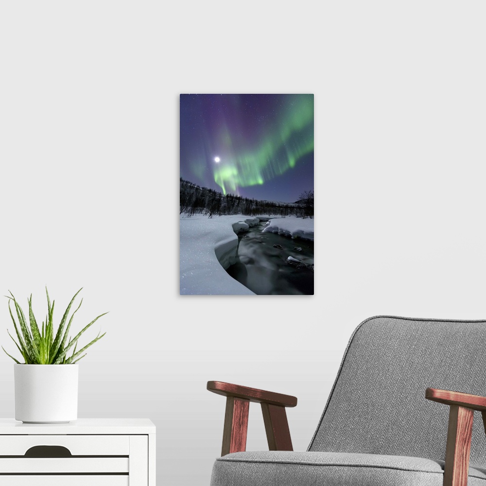 A modern room featuring Aurora Borealis and a full moon over the Blafjellelva River in Troms County, Norway. Auroras are ...
