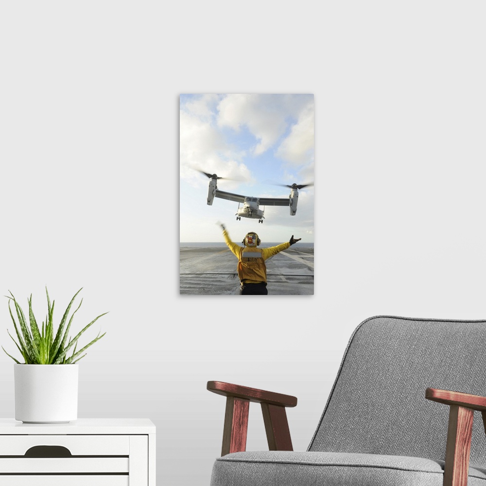 A modern room featuring Atlantic Ocean, February 5, 2012 - Aviation Boatswain's Mate signals an MV-22 Osprey to land on t...