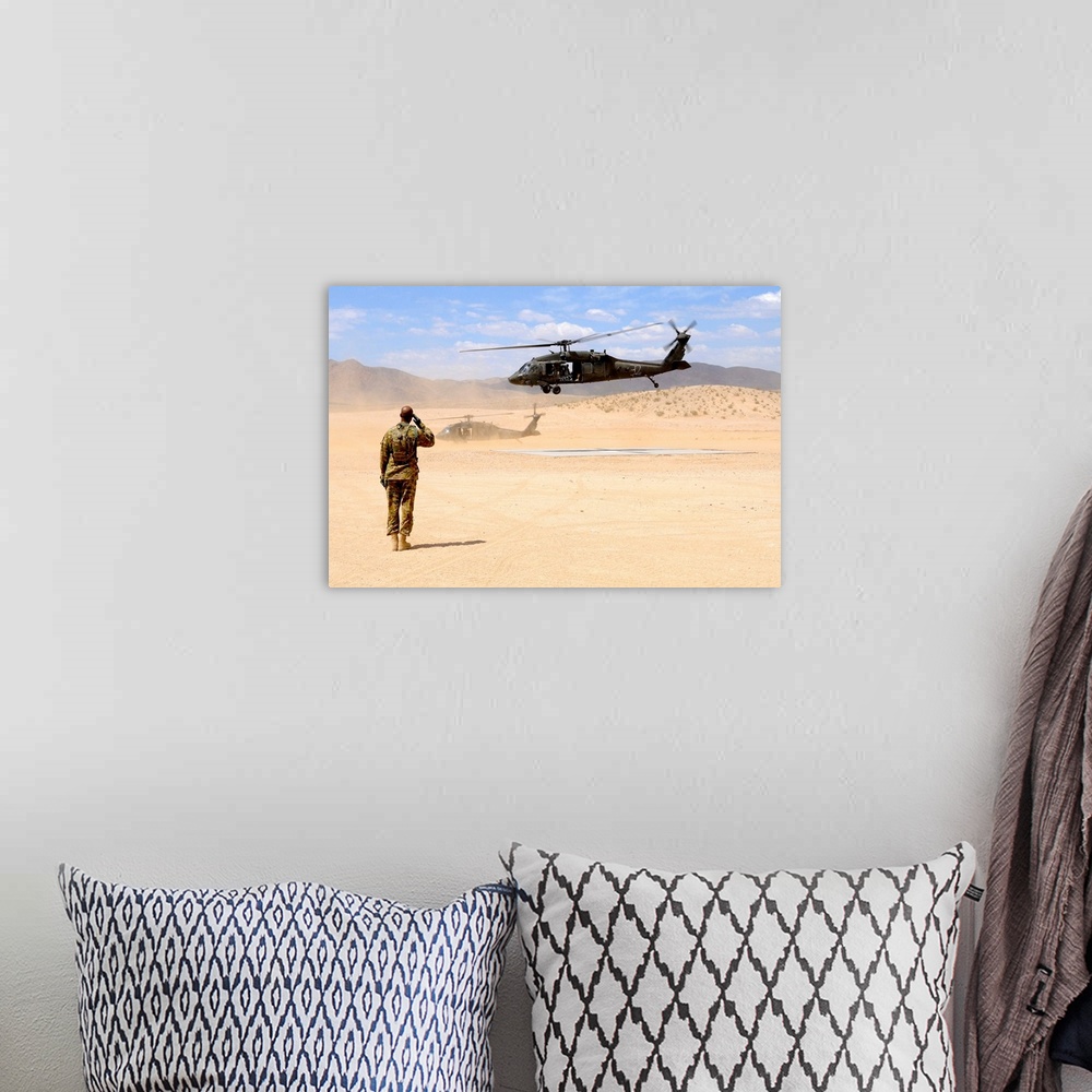 A bohemian room featuring August 4, 2012 - Brigade aviation officer salutes as a UH-60 Black Hawk helicopter lifts off from...