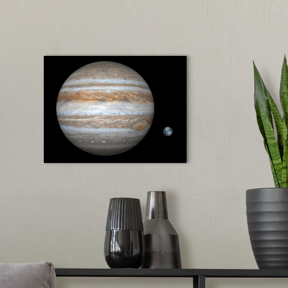 A modern room featuring Artist's concept comparing the size of the gas giant Jupiter with that of the Earth.