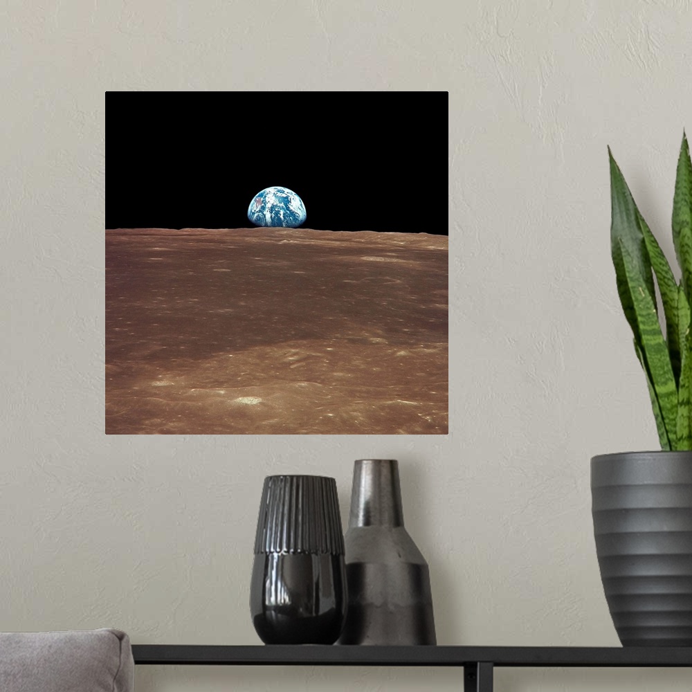 A modern room featuring View from the moon's surface of the earth rising over the horizon. It is a sight only a few astro...