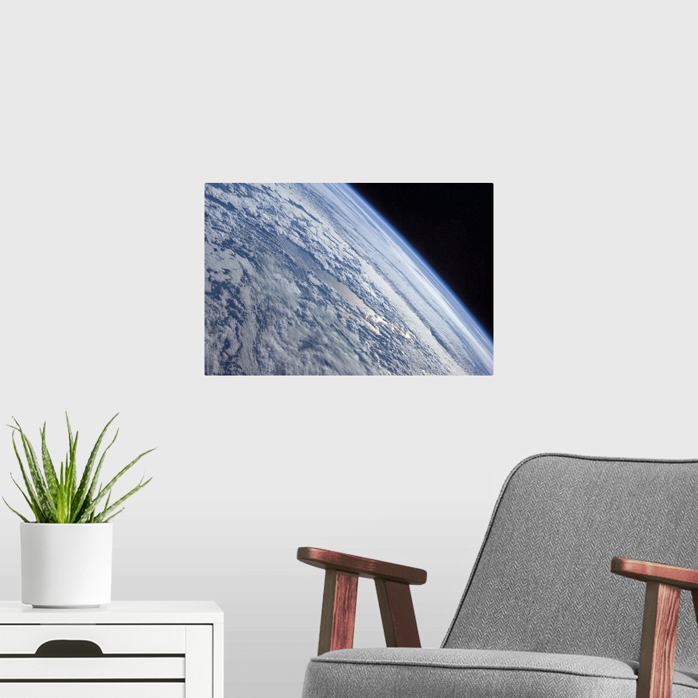 A modern room featuring Earths horizon against the blackness of space