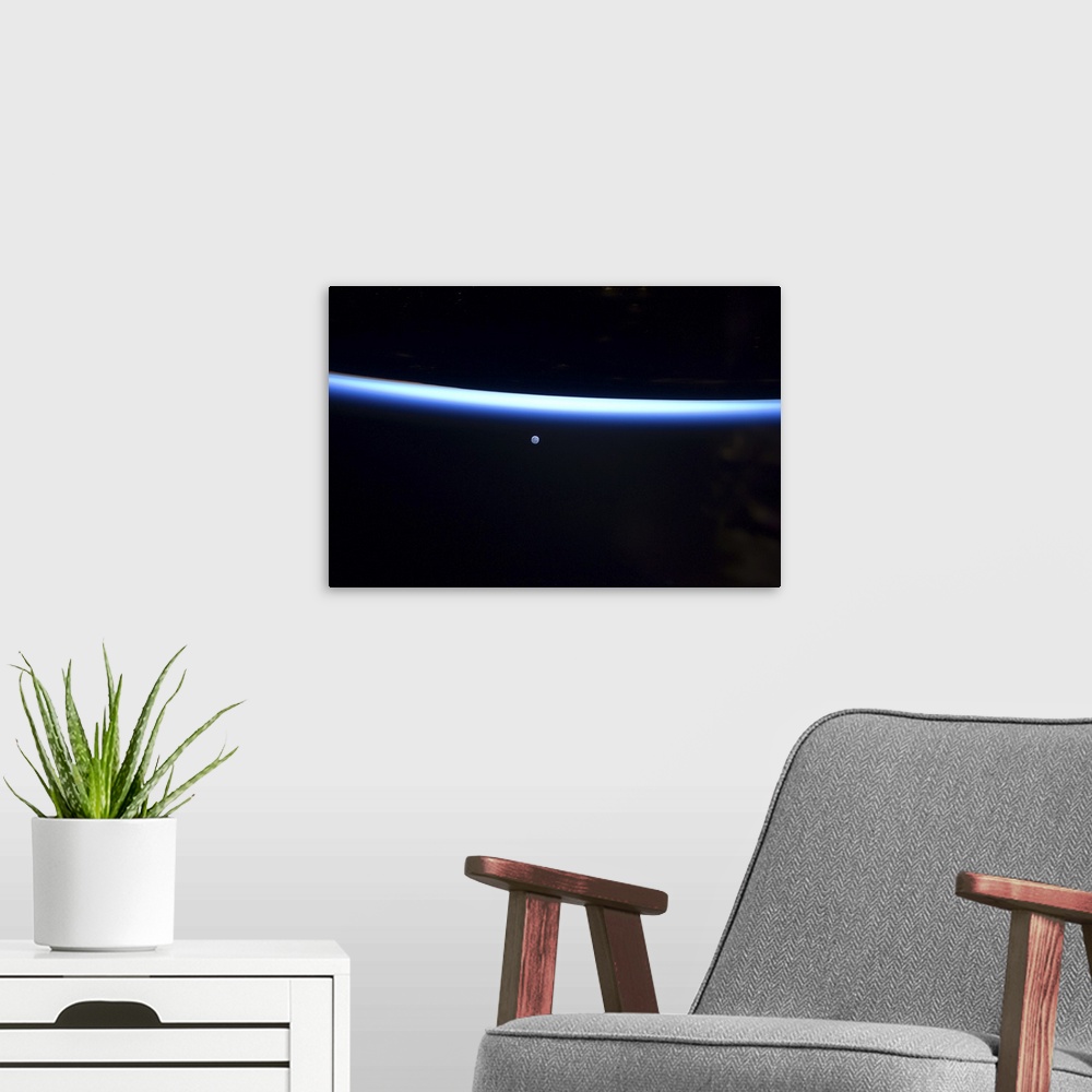 A modern room featuring March 6, 2011 - Earth's thin line of atmosphere and a gibbous moon.