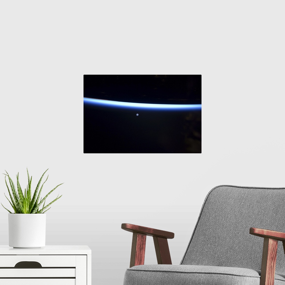 A modern room featuring March 6, 2011 - Earth's thin line of atmosphere and a gibbous moon.