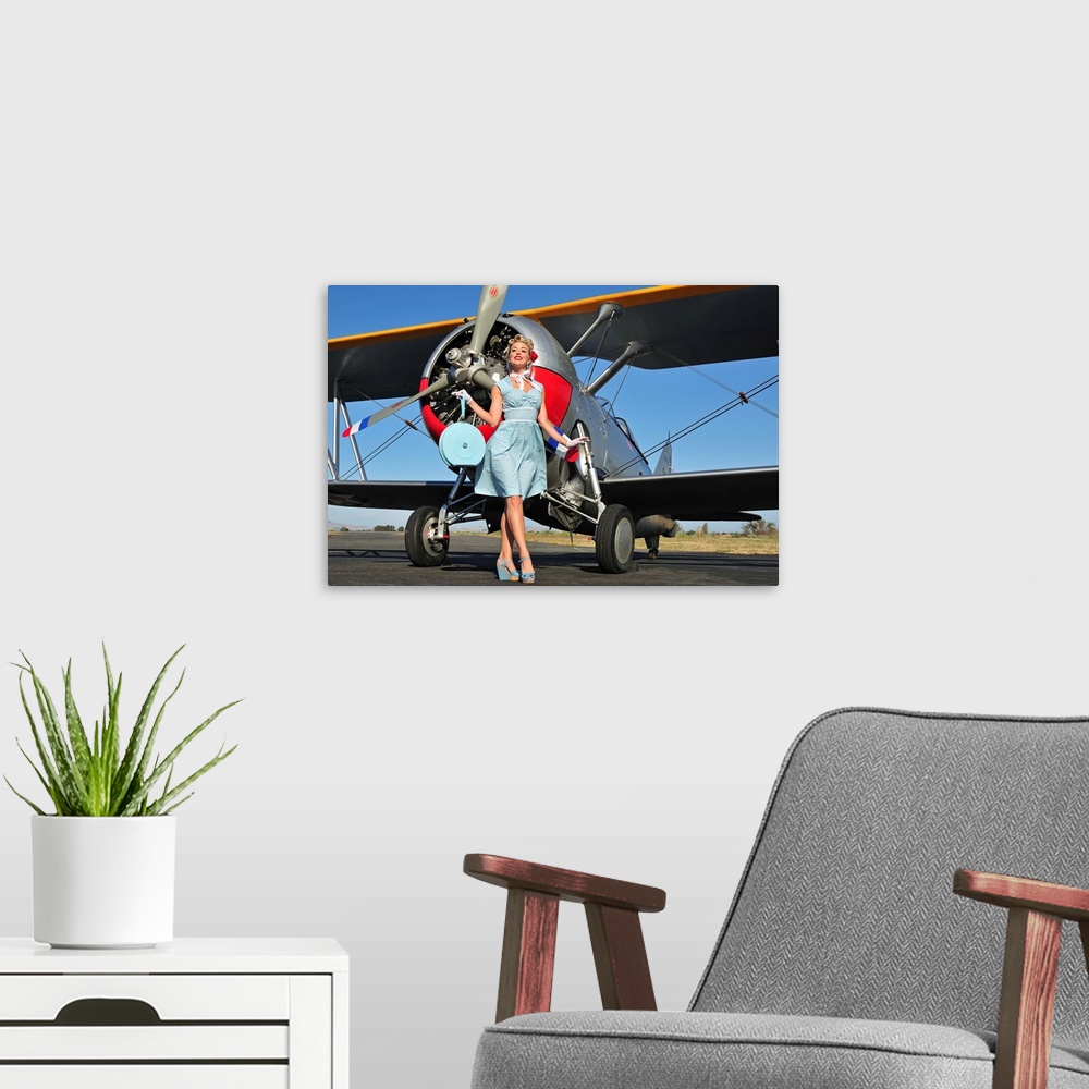 A modern room featuring Elegant 1940's style pin-up girl standing in front of an F3F biplane.
