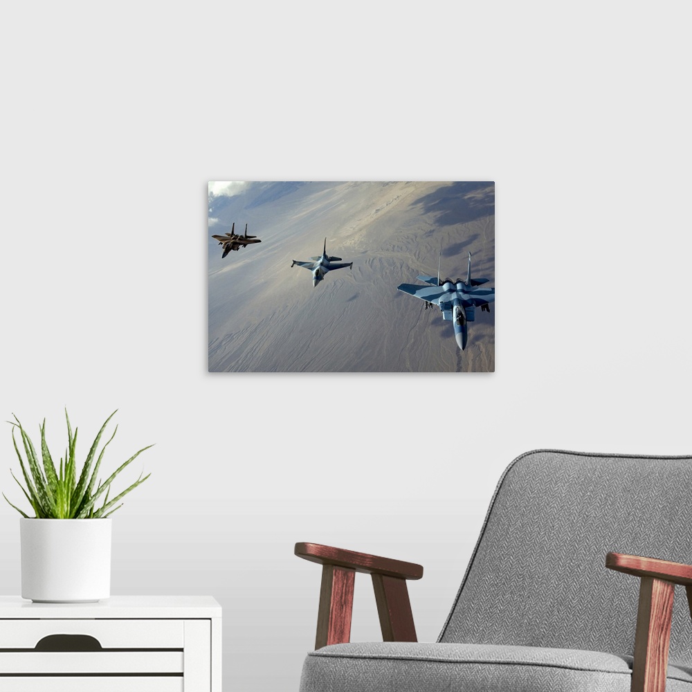 A modern room featuring Big photo on canvas of three fighter jets flying in a diagonal line formation above a desert.