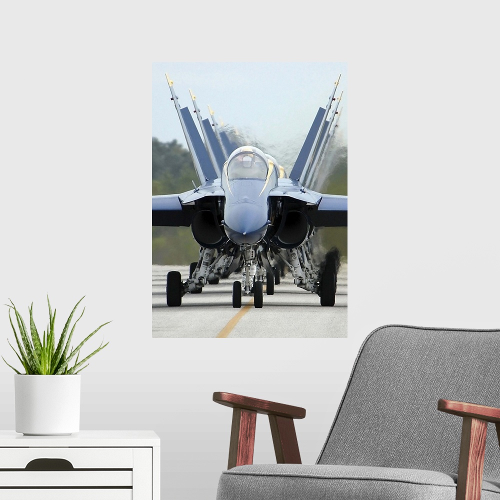 A modern room featuring F/A-18A Hornets assigned to the Blue Angels, taxi back to their flight line.