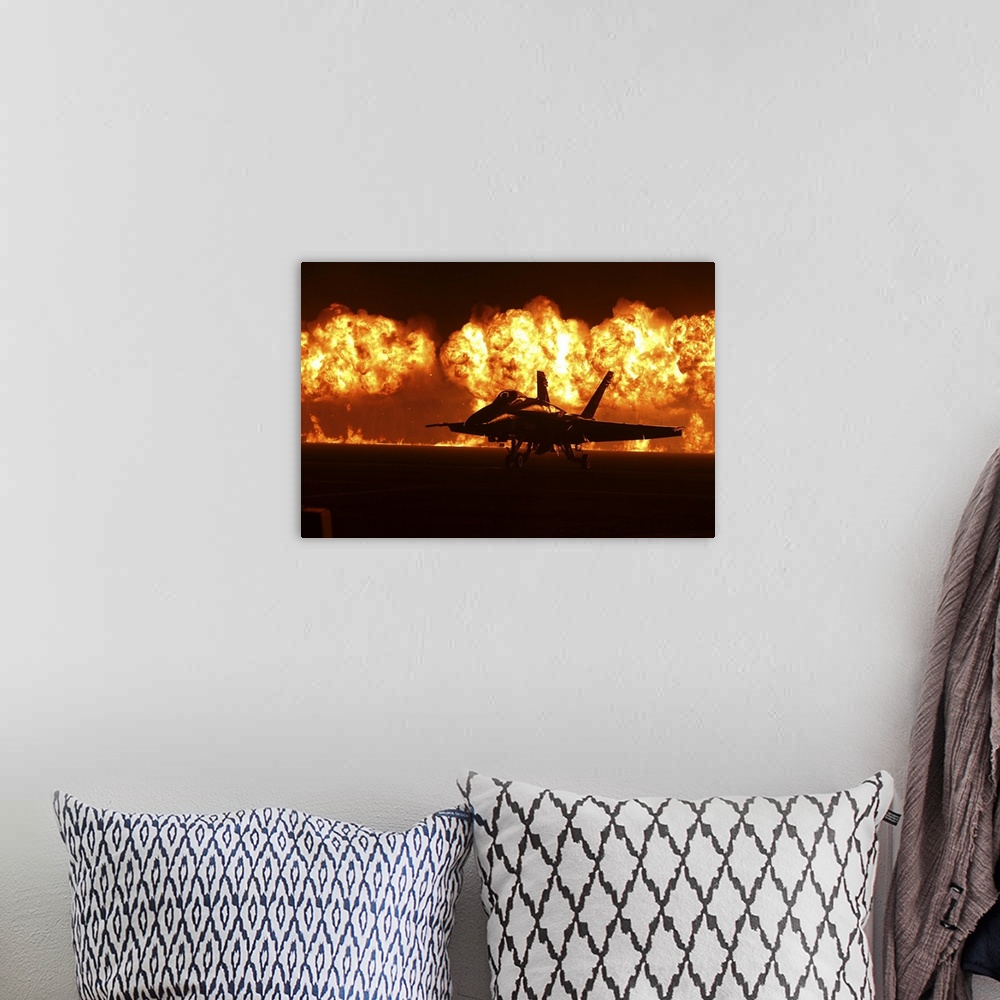 A bohemian room featuring Flames explode behind an F/A-18 Hornet of the U.S. Navy Blue Angels.