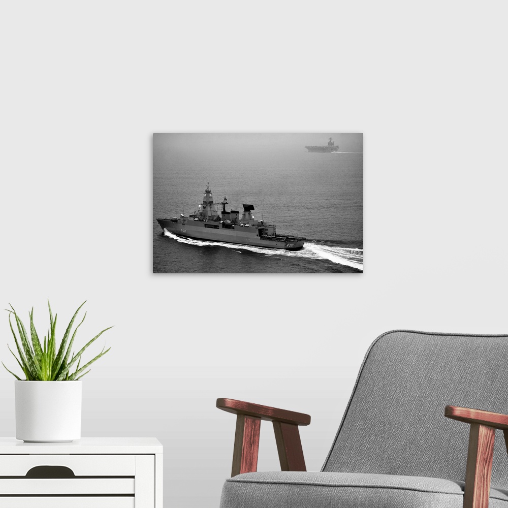 A modern room featuring German navy frigate FGS Hessen cruises alongside USS Harry S. Truman.