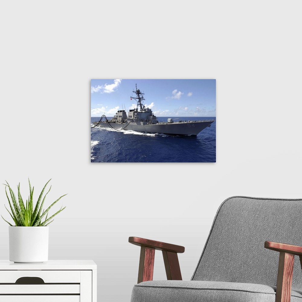 A modern room featuring Big canvas photo art of a navy ship in the ocean.