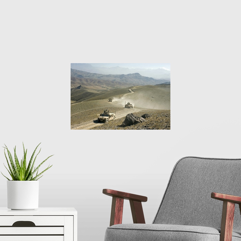A modern room featuring Humvees traverse rugged mountain roads