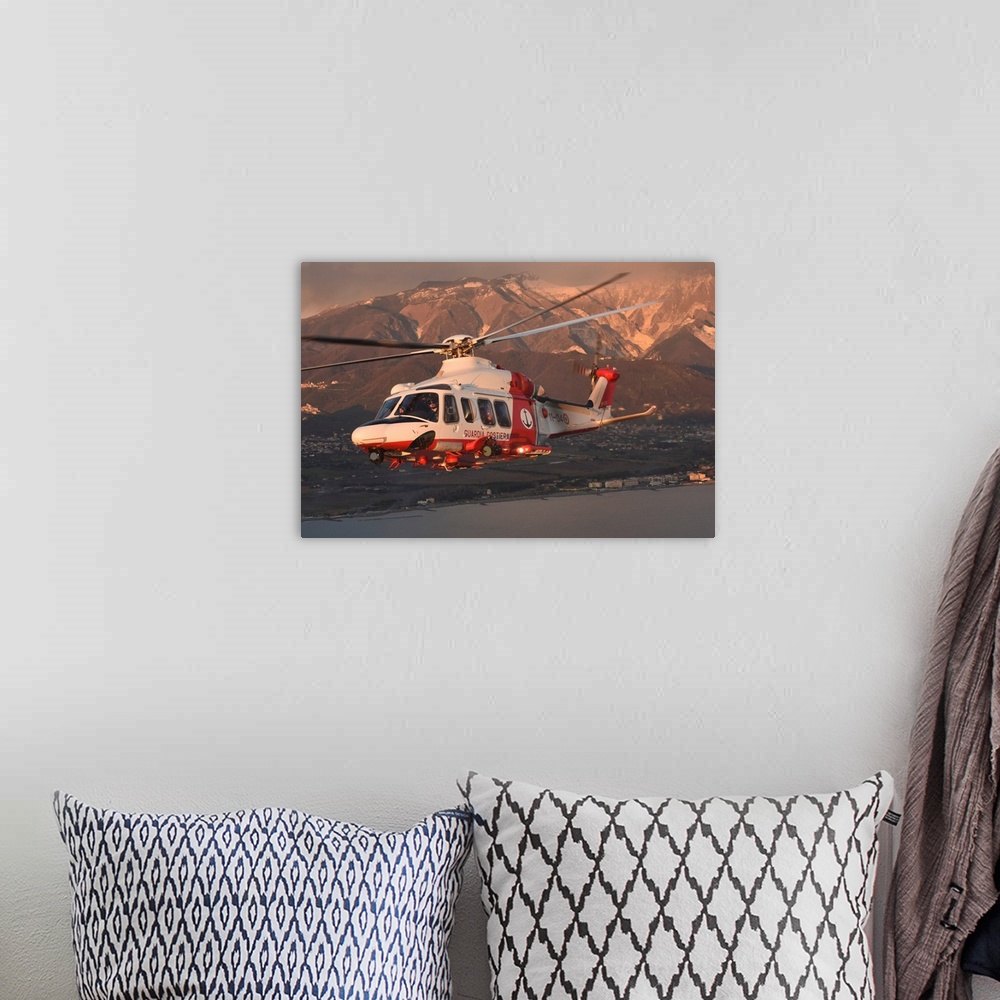 A bohemian room featuring Italian Coast Guard PH-139B helicopter taken in flight at sunset.