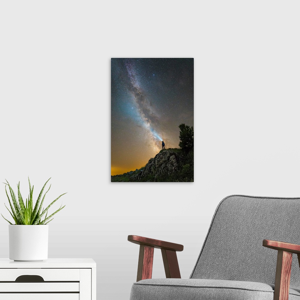 A modern room featuring Man shining a flashlight on the Milky Way from atop a mountain in Russia.