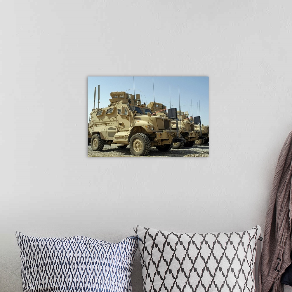 A bohemian room featuring Mine Resistant Ambush Protected vehicles sit in parking area at Joint Base Balad Iraq