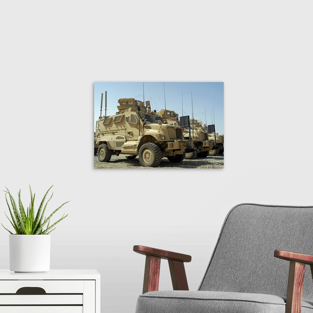 A modern room featuring Mine Resistant Ambush Protected vehicles sit in parking area at Joint Base Balad Iraq