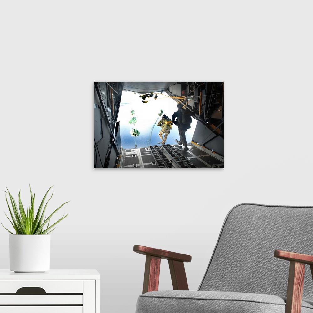 A modern room featuring Pararescuemen perform a static-line jump out of a C-130 Hercules.