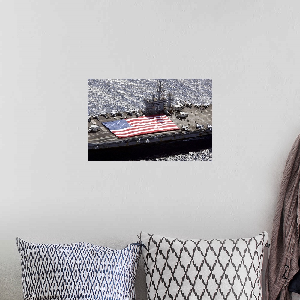 A bohemian room featuring Canvas print of a big American flag being held next to planes sitting on top of a huge navy ship.