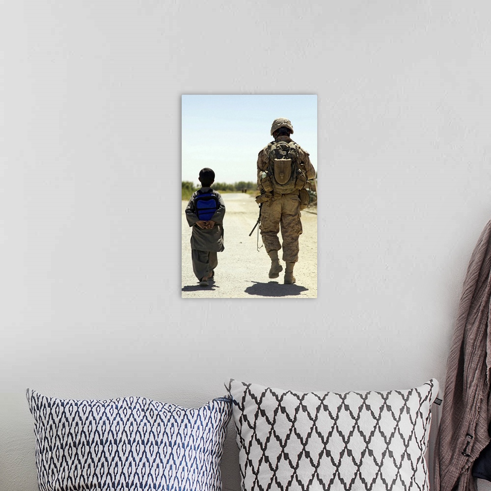 A bohemian room featuring Rear view of US Marine walking through Nawa bazaar with an Afghan boy in Afghanistan