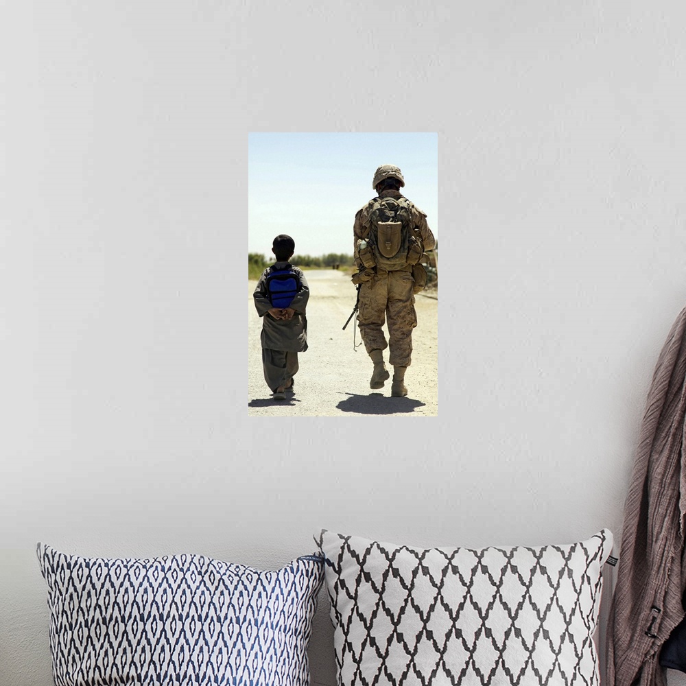 A bohemian room featuring Rear view of US Marine walking through Nawa bazaar with an Afghan boy in Afghanistan