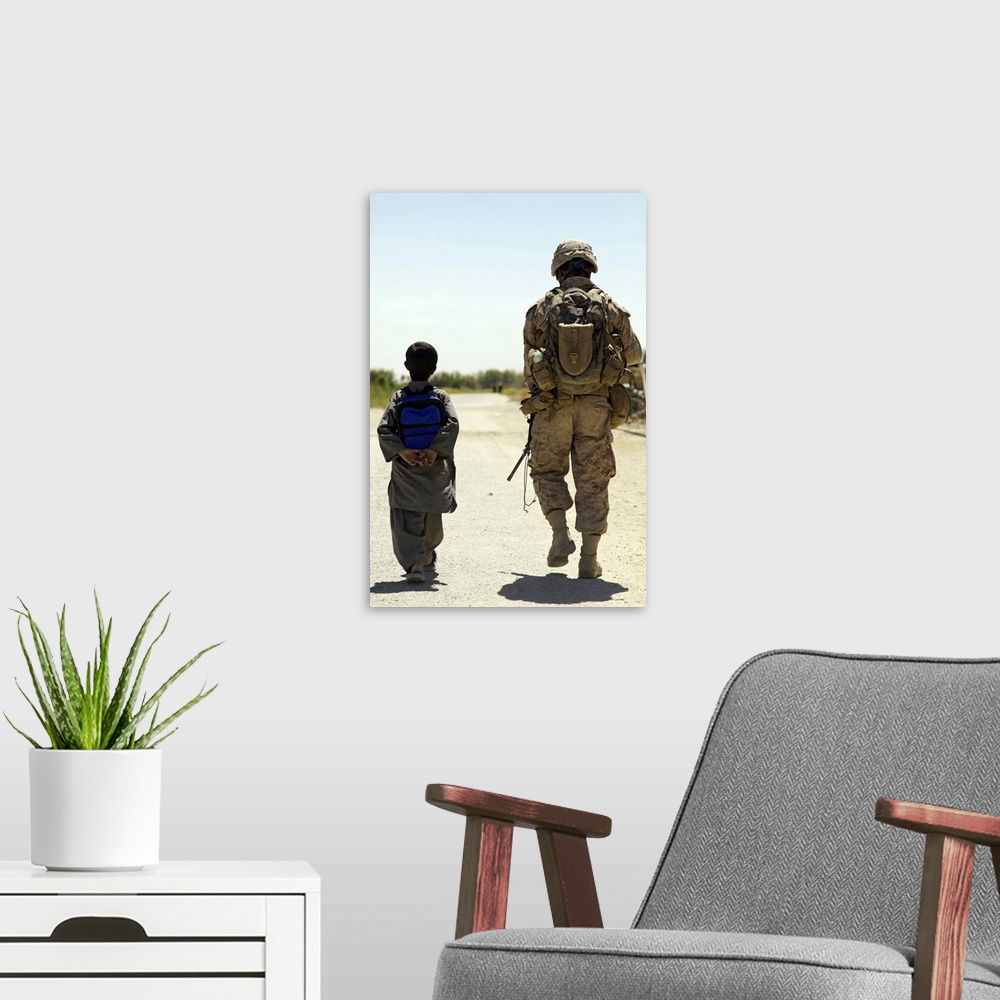 A modern room featuring Rear view of US Marine walking through Nawa bazaar with an Afghan boy in Afghanistan