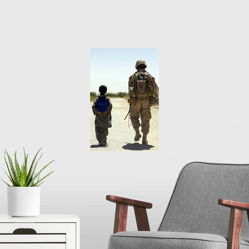A modern room featuring Rear view of US Marine walking through Nawa bazaar with an Afghan boy in Afghanistan