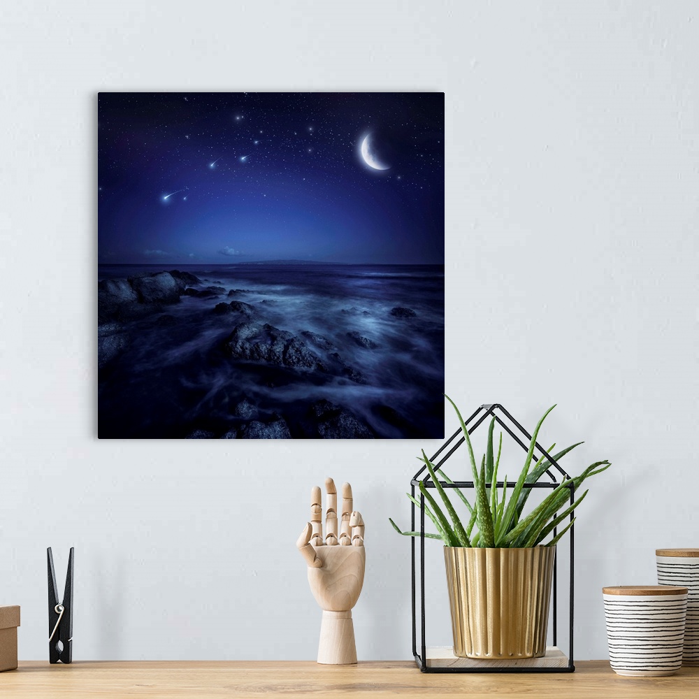 A bohemian room featuring Rising moon over ocean and boulders against starry sky and falling meteorites.