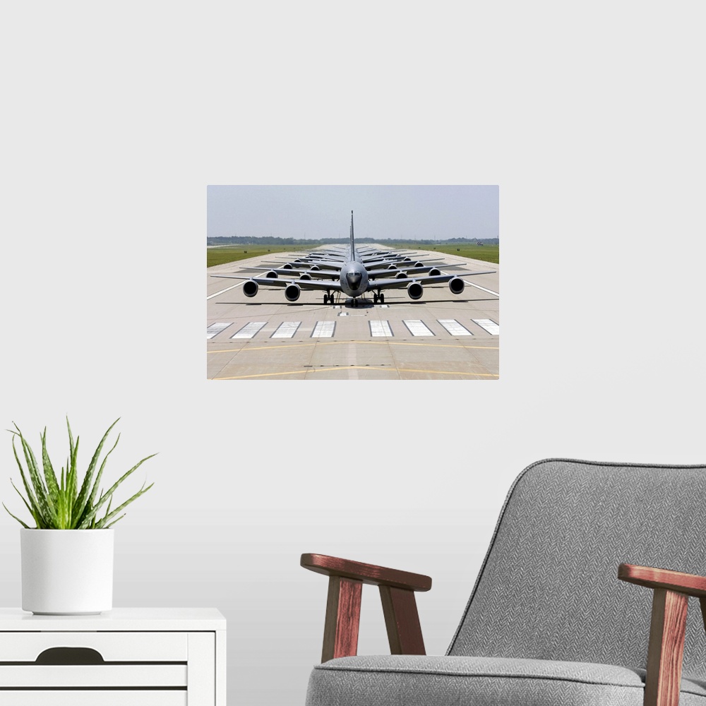 A modern room featuring Photograph of several large Stratotanker airplanes perfectly lined up in a row on a runway.