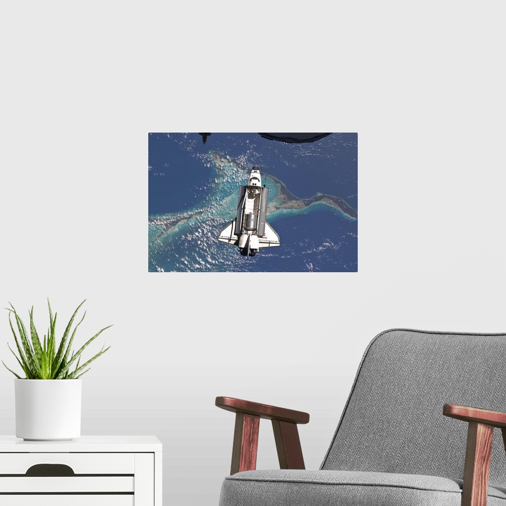 A modern room featuring July 10, 2011 - Space Shuttle Atlantis over the Bahamas. Part of a Russian Progress spacecraft is...