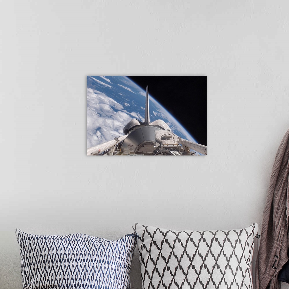 A bohemian room featuring Space Shuttle Discovery backdropped by Earth