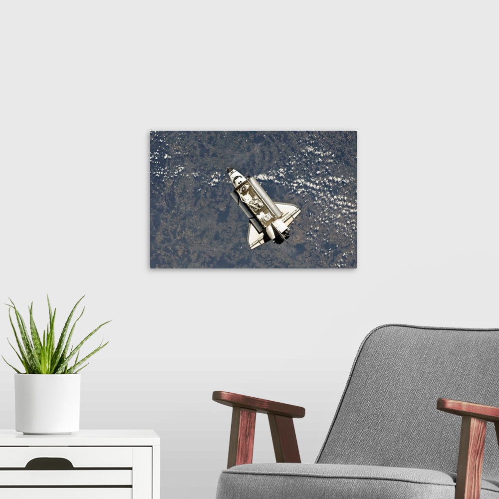 A modern room featuring May 18, 2011 - Space shuttle Endeavour backdropped by a colorful Earth.