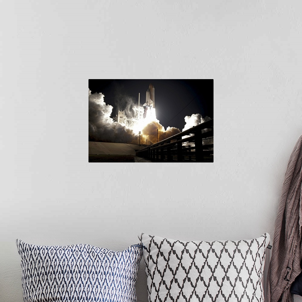 A bohemian room featuring Large horizontal photograph of the space shuttle Endeavour taking off from the launch pad at nigh...