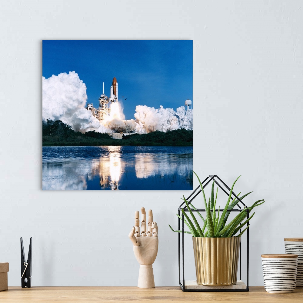 A bohemian room featuring A space shuttle launching into space on a bright clear day over the water.