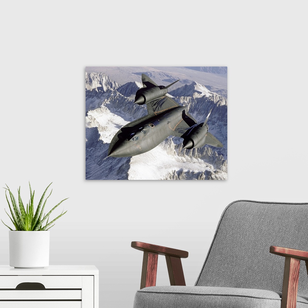 A modern room featuring A Lockheed SR-71 Blackbird spy plane flies over a mountain range as the sun shines down.