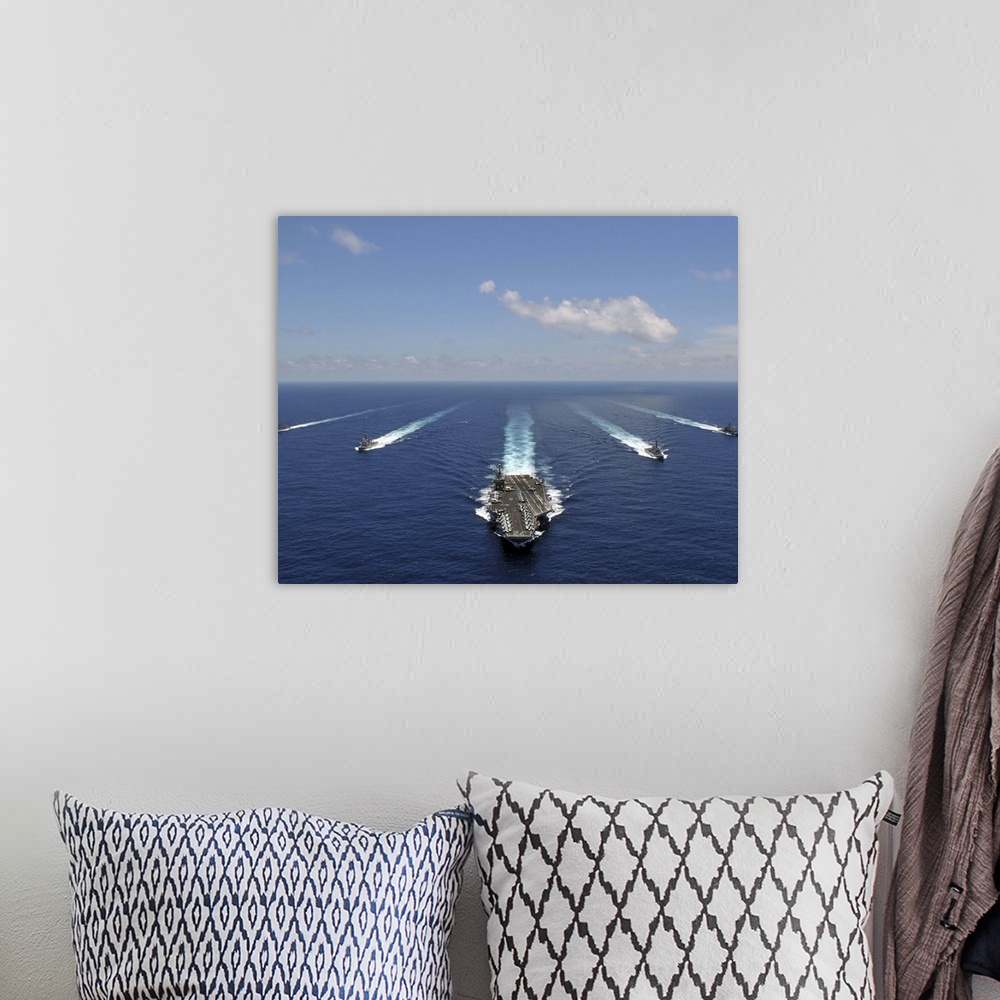 A bohemian room featuring The aircraft carrier USS Abraham Lincoln leading a formation of ships