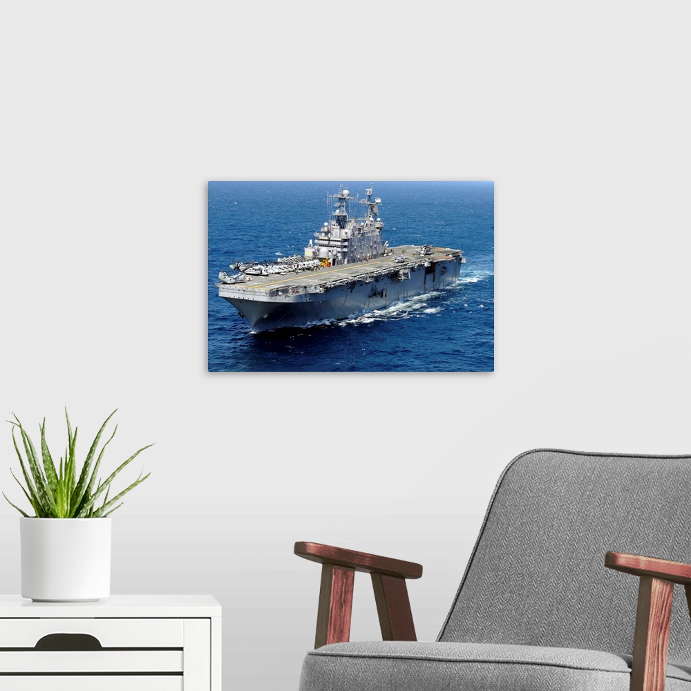 A modern room featuring The amphibious assault ship USS Peleliu in transit in the Pacific Ocean.