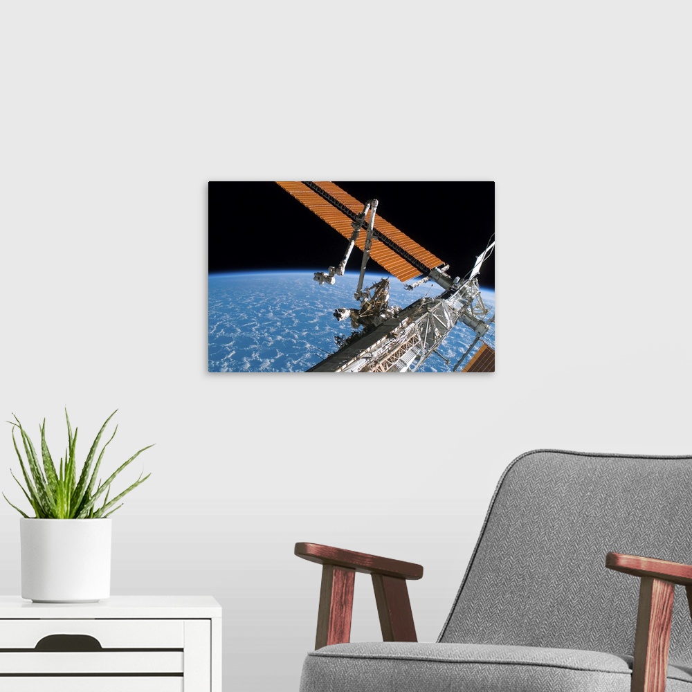A modern room featuring The Canadarm2 and solar array panel wings on the International Space Station