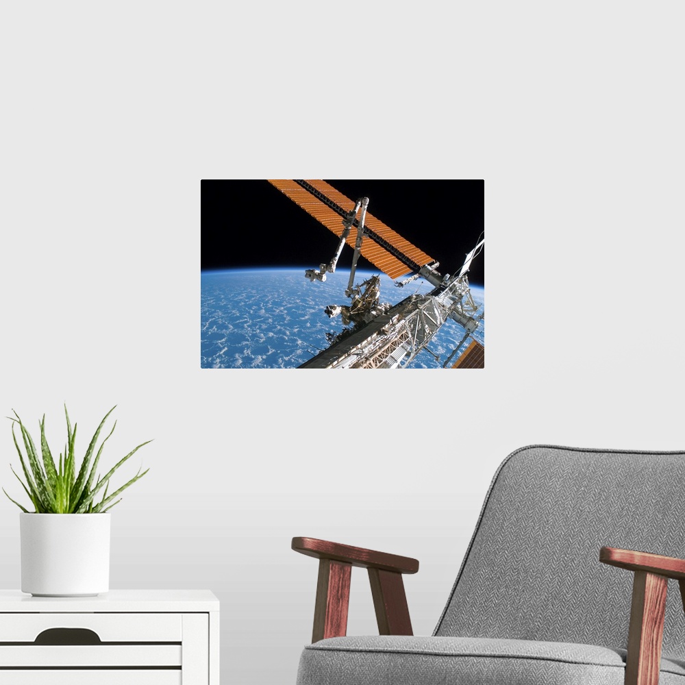 A modern room featuring The Canadarm2 and solar array panel wings on the International Space Station