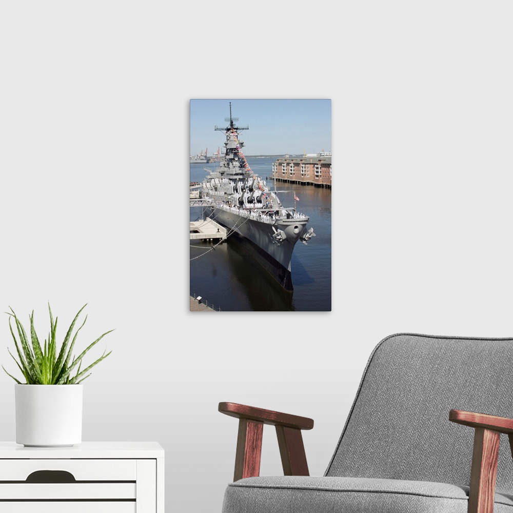 A modern room featuring The decommissioned US Navy Battleship USS Wisconsin berthed to the pier