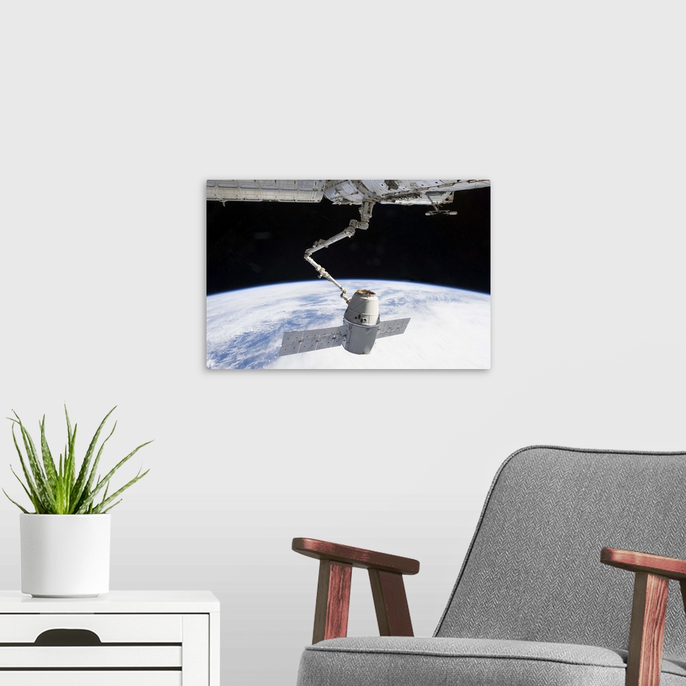 A modern room featuring March 3, 2013 - The docking of SpaceX Dragon to the International Space Station above a blue and ...