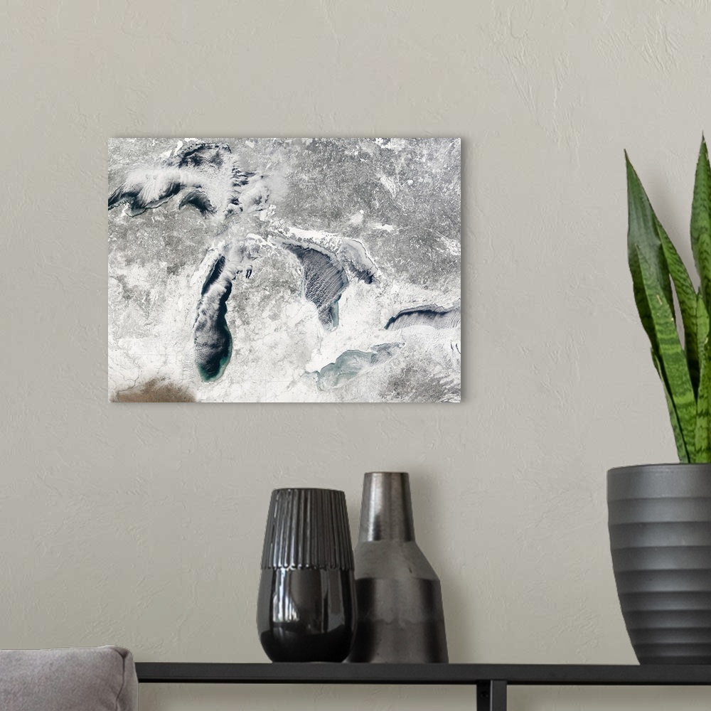 A modern room featuring A large aerial view of the great lakes during the winter season and covered in snow.