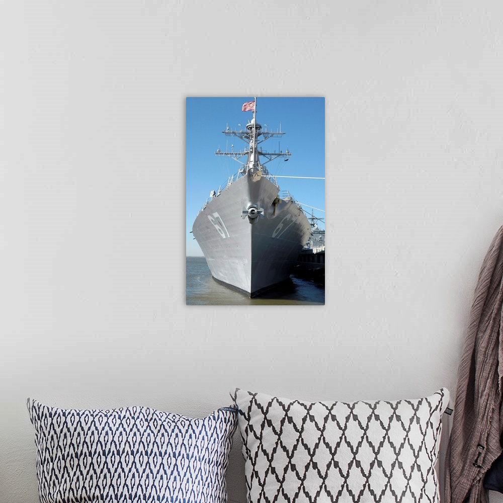 A bohemian room featuring The guided missile destroyer USS Cole sits moored to a pier