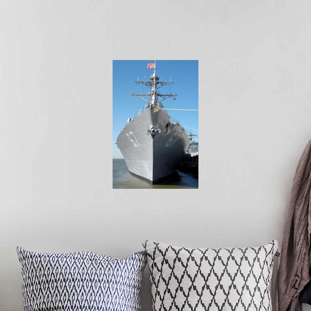 A bohemian room featuring The guided missile destroyer USS Cole sits moored to a pier